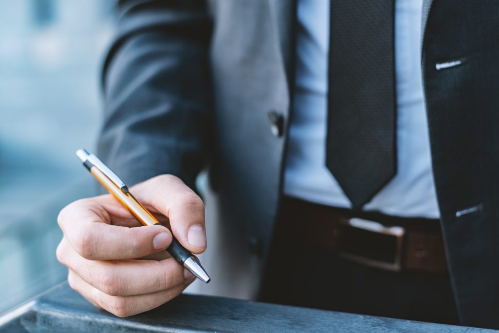 Man in a business suit holds a pen in his hand